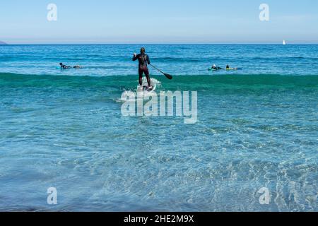 Impara a stare in piedi sulle onde dell'oceano in una giornata soleggiata e limpida a Canary Island Lanzarote Foto Stock