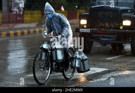 Jammu, Kashmir controllato dall'India. 8th Jan 2022. Un uomo del latte guida una bicicletta durante le piogge pesanti in Jammu, la capitale invernale del Kashmir indiano-controllato, 8 gennaio 2022. Credit: Str/Xinhua/Alamy Live News Foto Stock