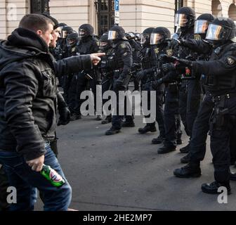 Magdeburg, Germania. 08th Jan 2022. Un partecipante al "cammino di pace" parla con i poliziotti. I manifestanti hanno attraversato Magdeburg per protestare contro le misure adottate dallo Stato di Sassonia-Anhalt per contenere il coronavirus con un "cammino di pace". Credit: Paul Zinken/dpa/Alamy Live News Foto Stock