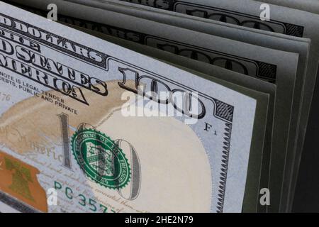 Cento fatture del dollaro accatastate in una linea - 100 banconote del dollaro in una pila. (Profondità di campo ridotta) Foto Stock