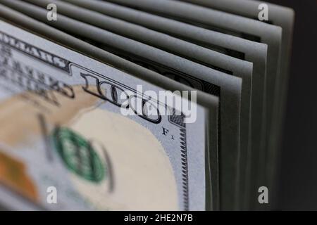 Cento fatture del dollaro accatastate in una linea - 100 banconote del dollaro in una pila. (Profondità di campo poco profonda) Foto Stock