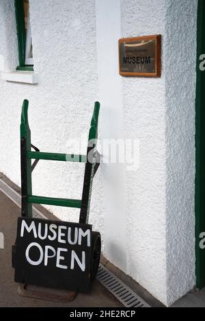 Oakhampton, Devon, Inghilterra, Regno Unito. 2021. Il museo della stazione di Oakhampton prende il nome da Arthur Westlake con un carrello portieri all'ingresso. Foto Stock