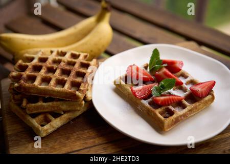 Waffle con fragole, banane e miele. Foto Stock