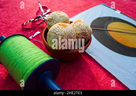 Ricetta Tilgul ladoo. Semi di sesamo bianchi ricoperti di zucchero gelificato. Palle dolci indiane servite mangiato indiano tradizionale mithai til bati . kites con l'uomo Foto Stock