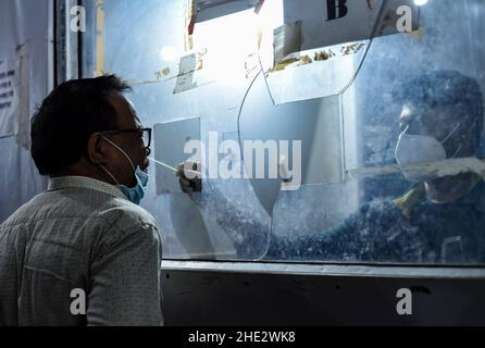 Guwahati, India. 08th Jan 2022. Un operatore sanitario raccoglie un campione di tampone per il test COVID-19 alla stazione ferroviaria di Guwahati, a Guwahati, Assam, India, sabato 8 gennaio, 2022. I casi giornalieri di Covid-19 sono saliti del 21% in 24 ore, in quanto l'India ha registrato più di cento mila infezioni fresche. Credit: David Talukdar/Alamy Live News Foto Stock