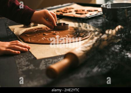 La mano dei bambini fa i biscotti heart-shape. Il bambino gioca con la pasta e la farina. Concetto di chef per bambini. Foto Stock