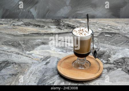 Caffè latte macchiato a strati di latte in un bicchiere alto. Foto Stock