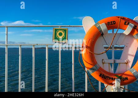 Salvataggio arancione con cartello accanto a esso a bordo del traghetto Red Eagle (imbuto rosso) a Southampton, Inghilterra, Regno Unito Foto Stock