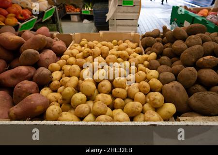 Patate alla rinfusa di specie diverse messe in vendita in un mercato Foto Stock