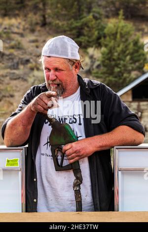 Junior, Longtime Mitchell; Oregon; residente; offre a un visitatore un cocktail pompato dalla sua stazione di benzina fuori rubinetto; Mitchell; Oregon; USA Foto Stock