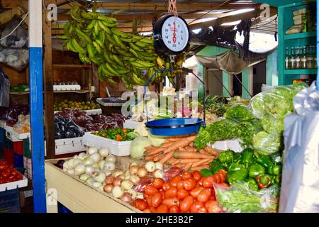 Verdure fresche e una bilancia per pesarle al mercato di Belize City in Belize. Foto Stock