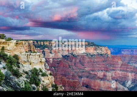 Nuvole di tempesta con aree rosa sulle scogliere rosse e bianche del Grand Canyon viste da Cape Royal sul versante nord del Parco Nazionale del Grand Canyon, AZ. Foto Stock