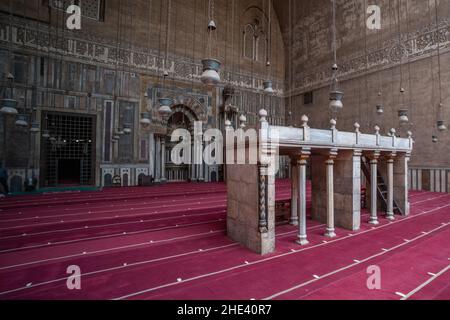 L'intricato marmo qibla, minbar, e mihrab di uno degli Iwan all'interno della moschea madrasa del Sultano Hassan al Cairo, Egitto. Un punto di riferimento storico. Foto Stock