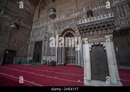 L'intricato marmo qibla, minbar, e mihrab di uno degli Iwan all'interno della moschea madrasa del Sultano Hassan al Cairo, Egitto. Un punto di riferimento storico. Foto Stock
