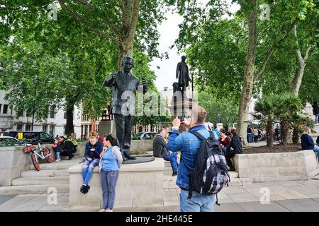 Uomo che fotografa la statua di Nelson Mandela presso la Piazza del Parlamento, Londra, Inghilterra Foto Stock