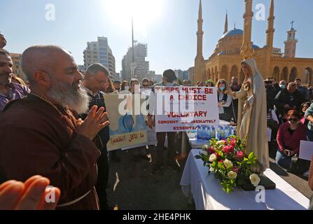 (220109) -- BEIRUT, 9 gennaio 2022 (Xinhua) -- Un pastore prega con persone che rifiutano la vaccinazione obbligatoria a Beirut, Libano, il 8 gennaio 2022. Decine di libanesi si sono riuniti in Piazza dei Martiri nel centro di Beirut, in Libano, sabato, rifiutando di avere vaccinazioni e chiedendo libertà di scelta tra l'aumento dei casi COVID-19 nel paese. Nel frattempo, con 7.547 nuovi casi COVID-19 registrati a livello nazionale sabato, l'onda COVID-19 Omicron, iniziata tre settimane fa in Libano, si è trasformata in uno "tsunami", ha avvertito il ministro della Sanità del paese Firas Abiad. Il conteggio nazionale ora è stato a 76 Foto Stock