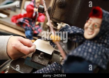 07 gennaio 2022, Sassonia-Anhalt, Thale: I volti delle statuine delle streghe sono formati con una stampa. La strega di Brocken e le figurine del diavolo sono fatte a mano nella manifattura delle streghe Thalens. I famosi souvenir delle Harz Mountains godono di popolarità generale tra i visitatori e gli ospiti. In diverse dimensioni e anche su misura, le figure sono costituite da un massimo di 20 parti, che vengono prodotte in officina della piccola manifattura. I clienti ordinano le figure mistiche lontano come l'Australia o persino l'America. I dipendenti della fabbrica di streghe utilizzano i mesi invernali principalmente per progettare nuove figure di strega e t Foto Stock