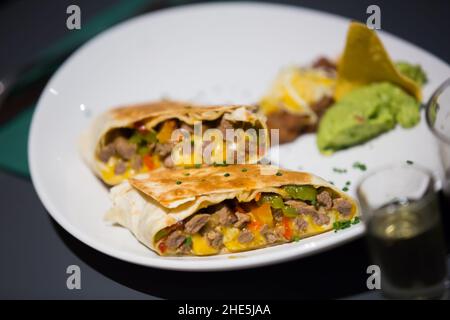 Burrito Tex-mex con carne in sause su piatto Foto Stock
