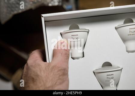 Lione, Francia - 14 dicembre 2021: Pacchetto di tenuta manuale POV maschio con nuove lampadine Philips hue White e Color GU10 per spot Foto Stock