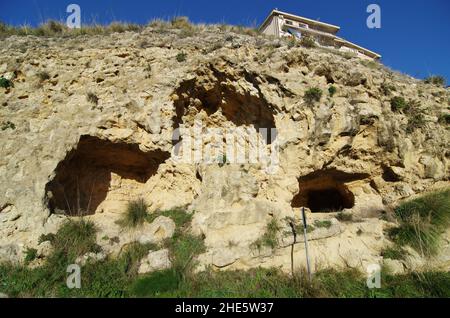 Parete rocciosa con grotta-casa troglodita in Sicilia Foto Stock