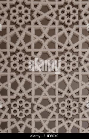 Stile arabo pietra intagliata arabesco apertura su una facciata di edificio nella Vecchia Dubai (Deira), con forme e motivi geometrici a stella e floreali. Foto Stock