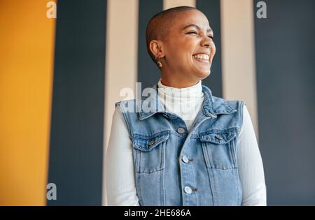 Donna d'affari entusiasta ridendo felicemente mentre si levano in piedi in un ufficio. Felice donna d'affari millennial che contempla le idee emozionanti di affari mentre standin Foto Stock