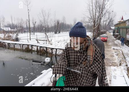 Srinagar, India. 08th Jan 2022. Un uomo si gesti durante una nevicata negli interni del lago dal. La regione del Kashmir ha ricevuto la prima nevicata di questa stagione, riducendo drasticamente le temperature e influendo sul traffico aereo e veicolare. (Foto di Idrees Abbas/SOPA Images/Sipa USA) Credit: Sipa USA/Alamy Live News Foto Stock