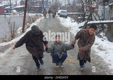 Srinagar, India. 08th Jan 2022. I bambini giocano tra le nevicate negli interni del lago dal. La regione del Kashmir ha ricevuto la prima nevicata di questa stagione, riducendo drasticamente le temperature e influendo sul traffico aereo e veicolare. (Foto di Idrees Abbas/SOPA Images/Sipa USA) Credit: Sipa USA/Alamy Live News Foto Stock