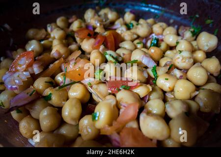 Un primo piano di insalata di ceci in un recipiente. Ricetta sana. Foto Stock