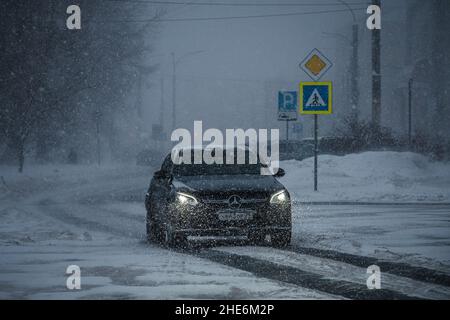 ARKHANGELSK, RUSSIA - GENNAIO 05 2022: Una macchina attraversa la città nella neve Foto Stock