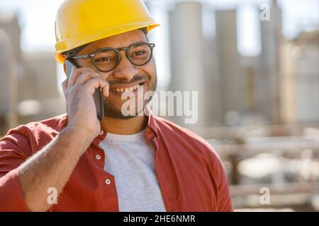 Sorridente giovane ingegnere industriale che lavora in stabilimento Foto Stock