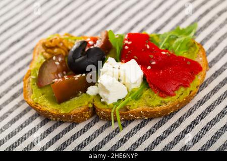 Sandwich con guacamole su fondo tessile a strisce Foto Stock