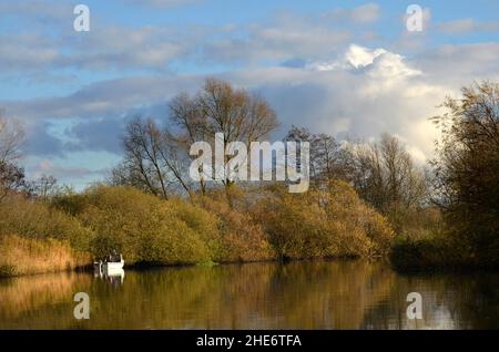 solitario pescatore barca sul fiume waveney a geldeston norfolk inghilterra Foto Stock