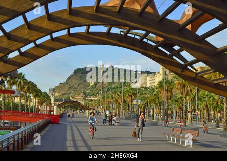 Moll de la Fusta - passerella pedonale e pista ciclabile accanto a Port Vell a Barcellona in Spagna. Montjuic collina sullo sfondo. Foto Stock