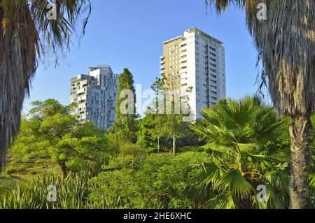 Rigoglioso paesaggio verde del Parc Diagonal Mar e proprietà moderne nel quartiere Sant Marti di Barcellona, Spagna. Foto Stock