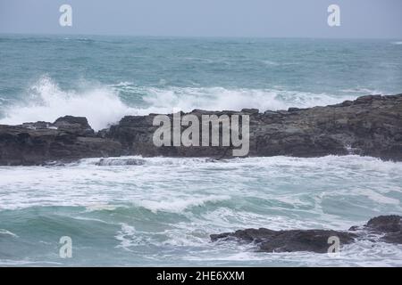 Godrevy, Cornovaglia, 9th gennaio 2022, gente fuori per una passeggiata mattutina in una giornata grigia, umida e triste a Godrevy, Cornovaglia. Sorprendentemente, alcune persone passeggiavano lungo le scogliere per guardare le foche e il faro di Godrevy anche se la temperatura era di 9C, ma con il fattore windchill sembrava molto più freddo.Credit: Keith Larby/Alamy Live News Foto Stock