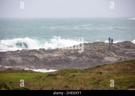 Godrevy, Cornovaglia, 9th gennaio 2022, gente fuori per una passeggiata mattutina in una giornata grigia, umida e triste a Godrevy, Cornovaglia. Sorprendentemente, alcune persone passeggiavano lungo le scogliere per guardare le foche e il faro di Godrevy anche se la temperatura era di 9C, ma con il fattore windchill sembrava molto più freddo.Credit: Keith Larby/Alamy Live News Foto Stock