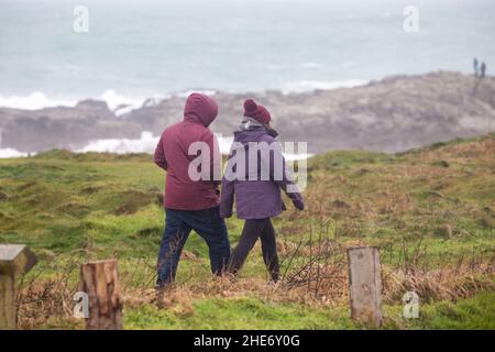 Godrevy, Cornovaglia, 9th gennaio 2022, gente fuori per una passeggiata mattutina in una giornata grigia, umida e triste a Godrevy, Cornovaglia. Sorprendentemente, alcune persone passeggiavano lungo le scogliere per guardare le foche e il faro di Godrevy anche se la temperatura era di 9C, ma con il fattore windchill sembrava molto più freddo.Credit: Keith Larby/Alamy Live News Foto Stock