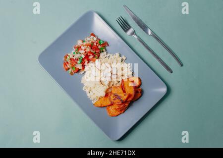 Delizioso cibo minimalista sfondo sudamericano piatto a base di piante patate dolci con cuscus e salsa pivre cilena Foto Stock