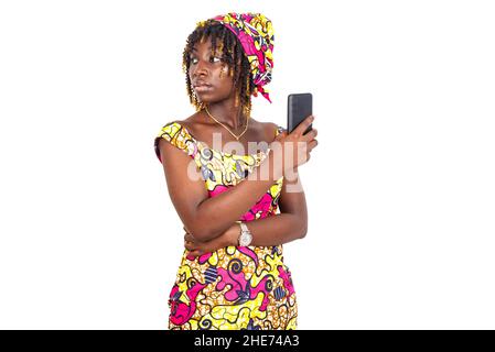 bella giovane donna che indossa il tradizionale lonstraccio che tiene il cellulare e guardando da parte. Foto Stock