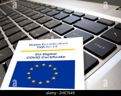 Primo piano del certificato verde Covid-19 del documento dell'Unione europea sulla tastiera di un notebook. Foto Stock