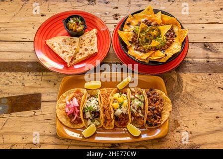 Cucina tradizionale messicana combinata con una degustazione di taco assortiti, quesadillas e nachos con guacamole e peperoncino Foto Stock