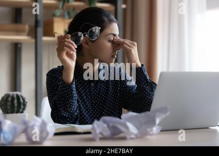 Stanco millennial indiano business donna sensazione di mal di testa Foto Stock