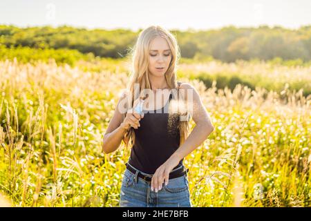 Repellente per zanzare. Insetti spray anti insetti per virus zika. Donna spruzzando repellente insetto mettere sulla pelle all'aperto in natura utilizzando flacone spray Foto Stock