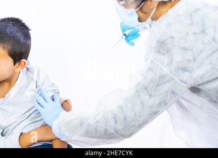 Bambino spaventato prima dell'iniezione del vaccino. Vaccinazione dei bambini. Immunizzazione nel coronavirus pandemico, covid-19 Foto Stock