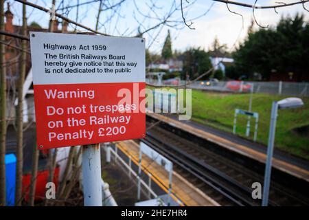 Non fatevi scovare dalla segnaletica che avverte le persone di non trasgressarsi sulla ferrovia alla stazione ferroviaria di Kenley nella zona sud di Londra Foto Stock