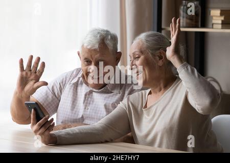 Gioiosa coppia di famiglia matura in attesa di videochiamata mobile. Foto Stock