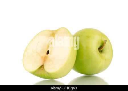 Una metà e una intera mela verde dolce su un piatto di argilla, primo piano, isolato su bianco. Foto Stock