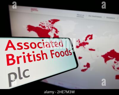 Cellulare con logo della società associati British Foods plc (ABF) sullo schermo di fronte al sito web aziendale. Concentrarsi sul centro del display del telefono. Foto Stock