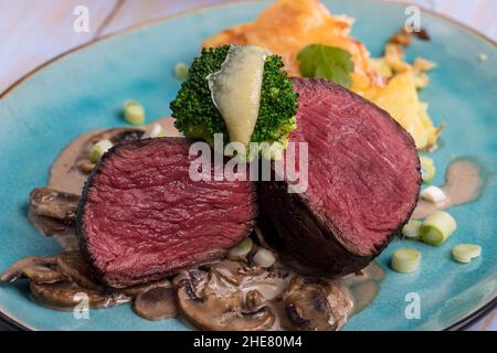 bistecca a fette e gratin di patate su un piatto Foto Stock